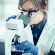 Professionnelle de santé observant un échantillon au microscope dans un contexte de recherche scientifique