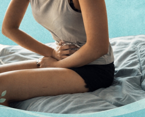 Femme assise sur un lit tenant son bas-ventre avec une zone rouge illustrant une douleur pelvienne liée aux règles douloureuses.