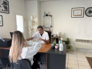 Guillaume Solaz, ostéopathe au Thor, échange avec une jeune patiente dans son cabinet